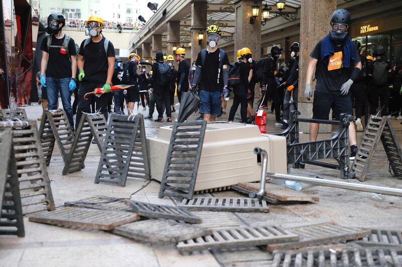 Demonstrators stand behind barricades during a protest in Hong Kong on Saturday. AP