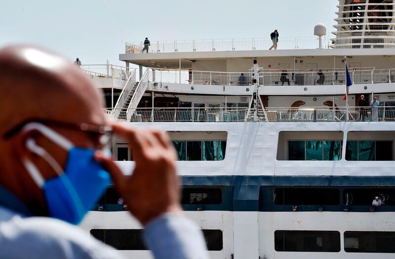 A man watches as passengers board a ship in the port of Algiers, the capital of Algeria, heading to the French port city of Marseille, in the first ferry between the two countries since the outbreak.  AFP