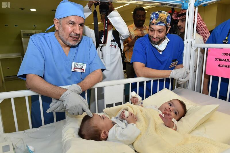 Saudi doctor Abdullah Al-Rabeeah (left) and a member of his medical team looking at Libyan conjoined twins before an operation to separate them, at King Abdulaziz Medical City in Riyadh.  AFP