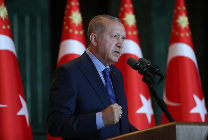 Turkey's President Recep Tayyip Erdogan, gestures as he delivers a speech to Turkish ambassadors at the Presidential Palace in Turkey, Monday, Aug. 13, 2018. Erdogan says his country is under an economic "siege" that has nothing to do with its economic indicators. He insisted that Turkey's economic dynamic remain strong and said the Turkish currency would soon settle "at the most reasonable level." (Pool Photo via AP)