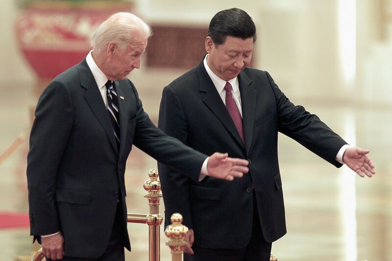 Mr Biden and Mr Xi make their way to view an honour guard during a welcoming ceremony in Beijing in August 2011. Getty