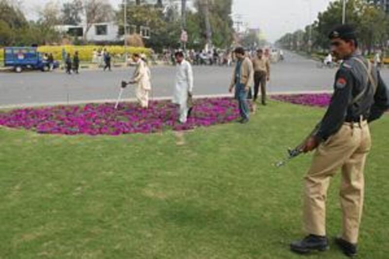 Security officials search the scene of the attack on the Sri Lankan cricket team in Lahore yesterday.