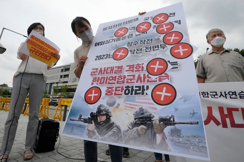 A protester holds a banner during a rally to oppose the joint military exercises being held by the US and South Korea. AP
