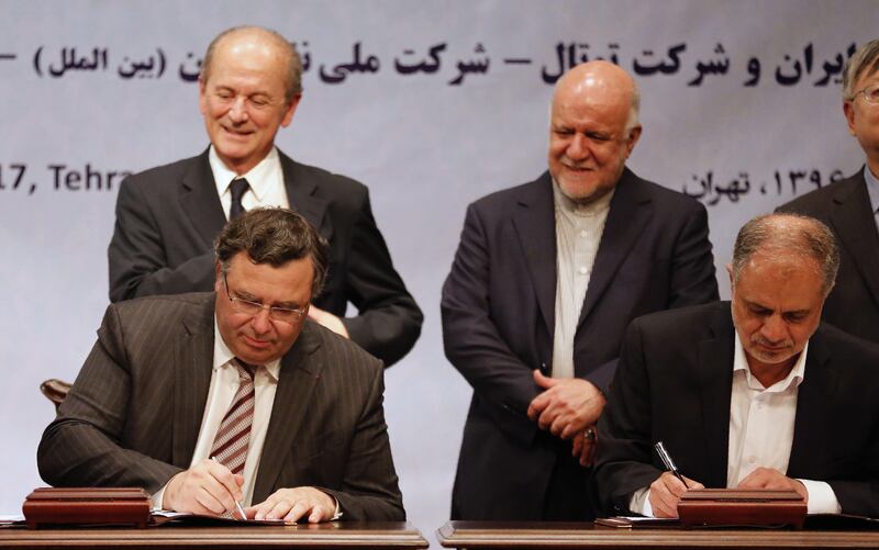 Iranian Oil Minister Bijan Namadar Zanganeh (C-R) looks on as Patrick Pouyanne (L), Chairman and CEO of French energy company Total, and Ezzatollah Akbari, Managing Director of Petropars Group, sign an offshore gas field agreement in Tehran, on July 3. Atta Kenare / AFP