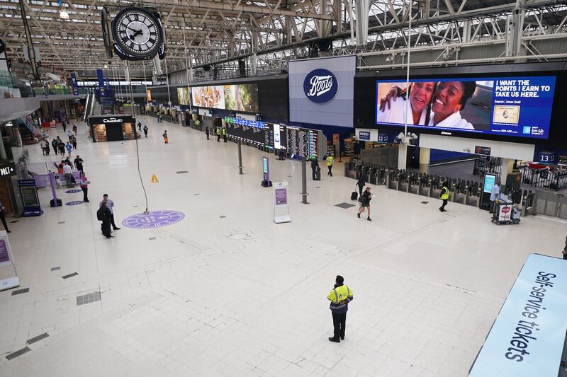 Passengers at a deserted Waterloo East station in London. PA