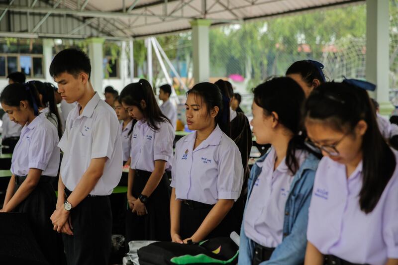 Classmates of the Wild Boars soccer team pray at the Maisai Prasitsart school before classes the morning as the third rescue mission to free the last four boys and their coach from a flooded cave gets underway. Getty Images