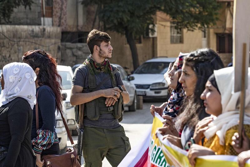 A member of the Kurdish Internal Security Force known as Asayesh stands guard during a protest against the Turkish assault on northeastern Syria, in the town of Qamishli. AFP