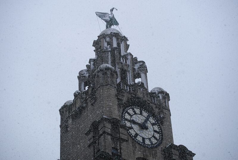 Snow falls around the Liver Building in Liverpool. PA