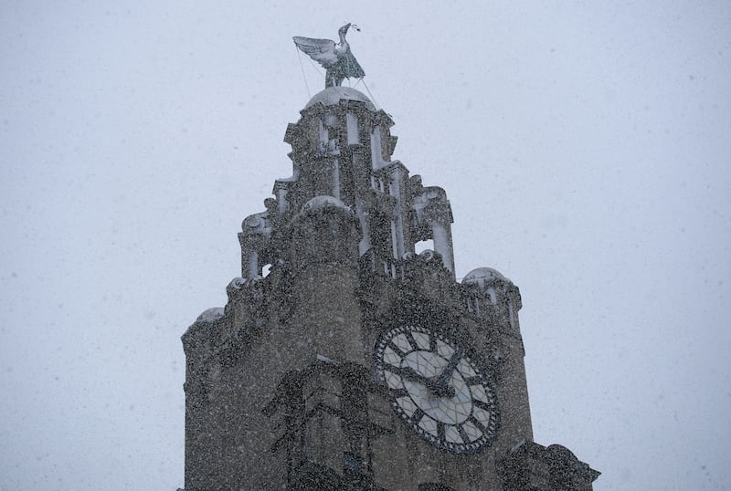 Snow falls around the Liver Building in Liverpool. PA