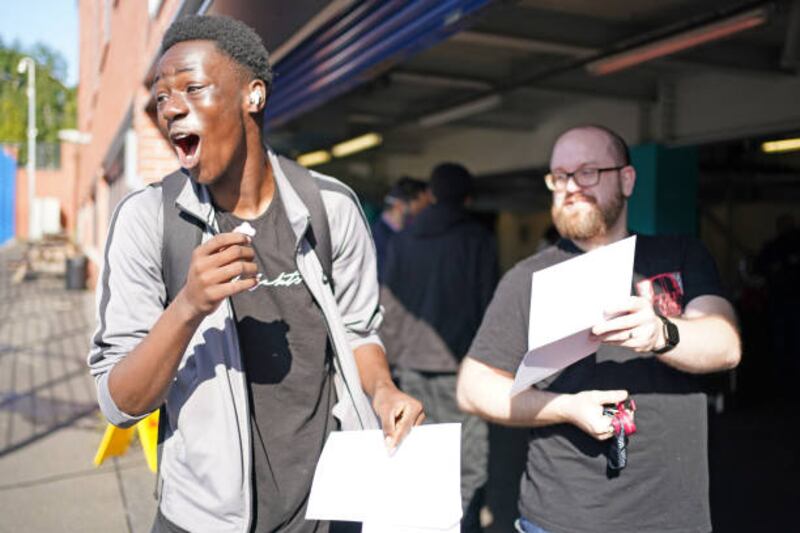 Joy Israel Mbengo celebrates with English teacher Steve Parkes as he opens his GCSE results at Core's City Academy in Birmingham.