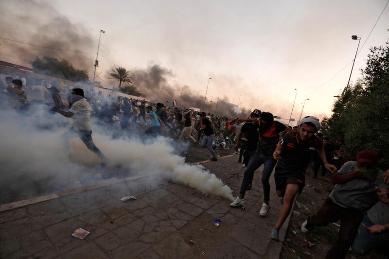 Demonstrators run as Iraqi security forces use tear gas during a protest in Baghdad, Iraq. Reuters