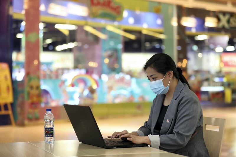 Dubai, United Arab Emirates - Reporter: N/A. News. Coronavirus/Covid-19. A lady works on her laptop while wearing a mask at Times Square in Dubai. Tuesday, October 20th, 2020. Dubai. Chris Whiteoak / The National
