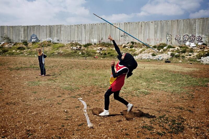West Bank: Students from the Al-Quds University javelin team wrap up the last practice before summer vacation in the West Bank city of Abu Dis, next to the Israeli Separation Wall. Courtesy Tanya Habjouqa