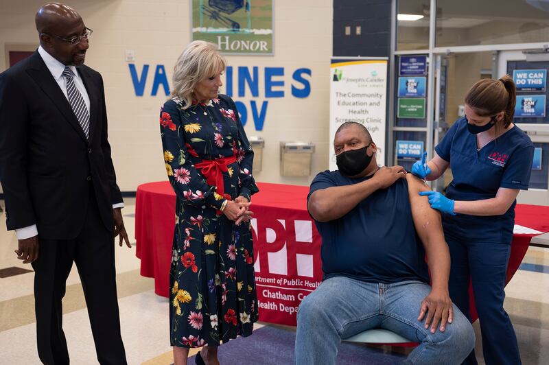 First lady Jill Biden and Mr Warnock look on as a man is vaccinated against Covid-19 in Savannah, Georgia. AP