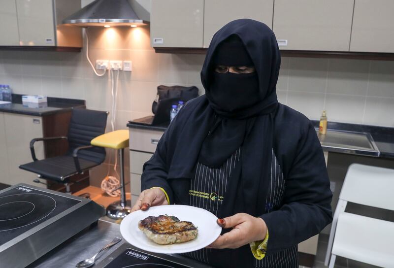 A participant presents her dish to the cooking class.