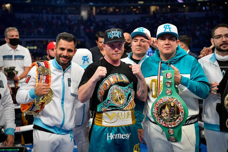 Saul Alvarez celebrates with his team and the belts after defeating Billy Joe Saunders in a super middleweight boxing title fight at AT&T Stadium. Reuters