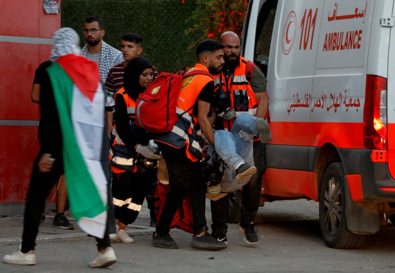 Medics carry an injured person to an ambulance amid confrontations between Palestinians and Israeli forces. Reuters