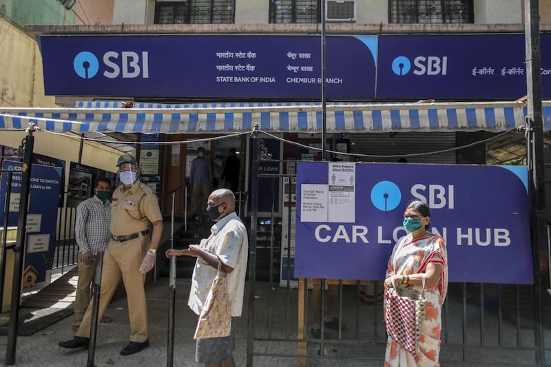 Customers wait in line at a State Bank of India (SBI) branch in Mumbai, India, on Monday, May 4, 2020. India's central bank Governor Shaktikanta Das and the chief executive officers of the nation's banks have discussed ways to ensure credit flow to businesses once the world's toughest stay-at-home order ends. Photographer: Dhiraj Singh/Bloomberg