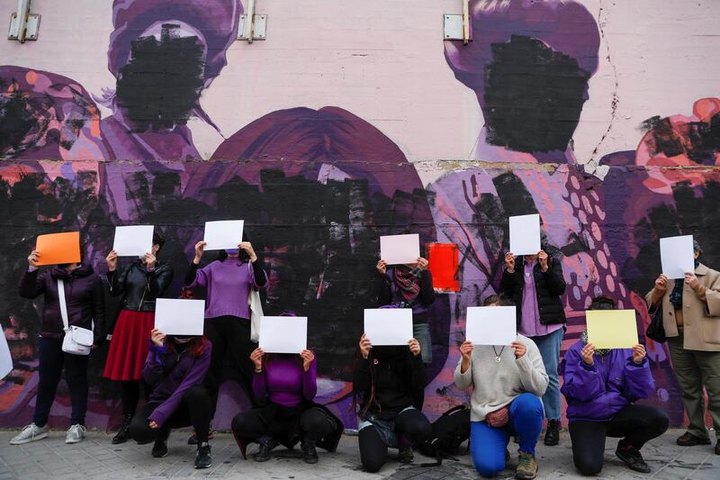 Women protest by covering their faces next to a vandalised mural showcasing feminist figures, on International Women's Day, in Madrid, Spain. Reuters