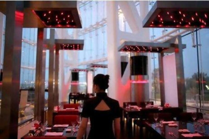 The decor at Rouge, Rocco Forte, Abu Dhabi, features red lighting and tables that run around the edge of the room .