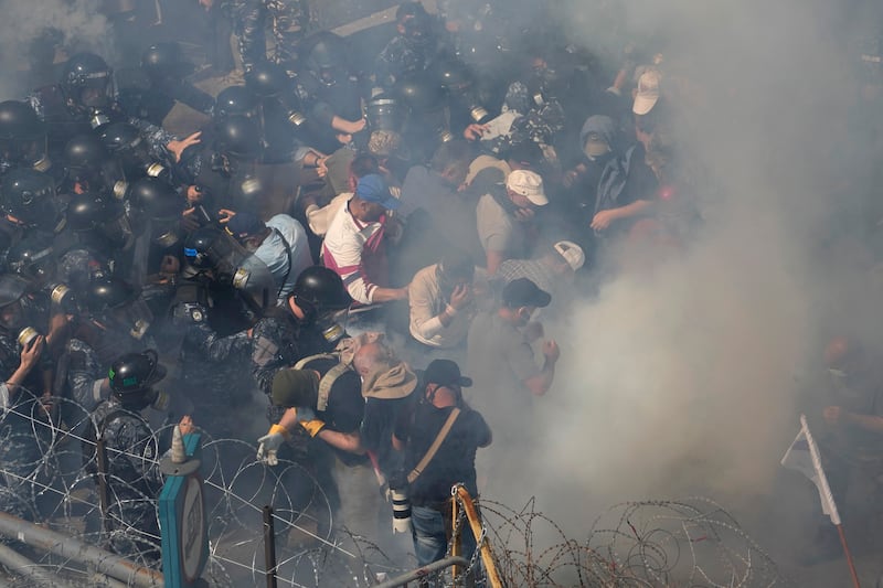 Protesters run away from tear gas. AP Photo 