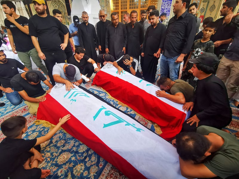 Mourners pray in front of the coffins of Al Sadr supporters. Reuters