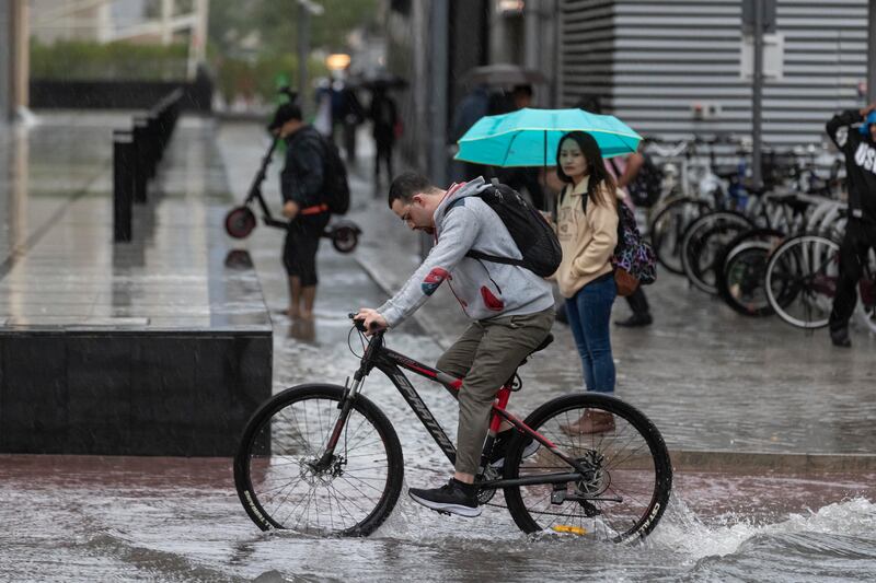 A man pedals through the rain on his bicycle, in Barsha Heights. Antonie Robertson/The National