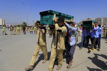 Yemeni children help carrying coffins of schoolchildren killed in an explosion near two schools in the capital Sanaa. AFP 