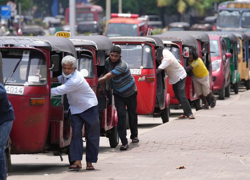 Sri Lankan auto rickshaw drivers queue up to buy petrol near a fuel station in Colombo, Sri Lanka, Wednesday, April 13, 2022.  Sri Lanka's prime minister on Wednesday offered to meet with protesters occupying the entrance to the president's office, saying he would listen to their ideas to resolve the economic, social and political challenges facing the country.  (AP Photo / Eranga Jayawardena)