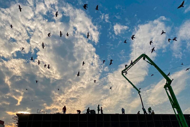Workers are seen on top of an under-construction bridge in Vadodara, Gujarat. AFP