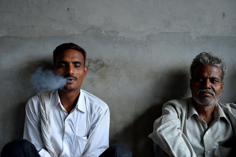 Workers smoke during a break at The New Sarkar Bidi Factory in Kannauj.