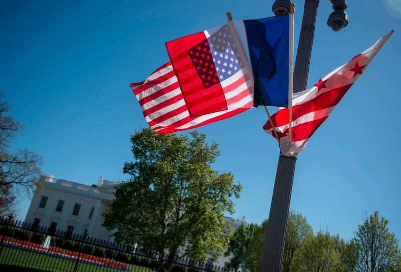 A US national flag, French flag(C) and Washington,DC flag fly near the White House in Washington, DC on April 20, 2018, the week before the visit of French President Emmanuel Macron.                           / AFP PHOTO / Andrew CABALLERO-REYNOLDS