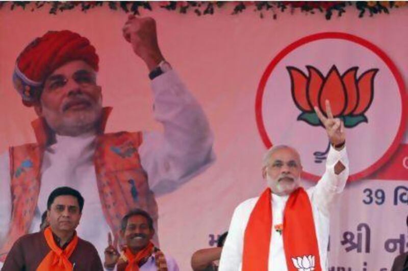 Gujarat chief minister Narendra Modi, right, flashes a victory sign during an election campaign at Viramgam in Gujarat. He is widely expected to be swept into office.