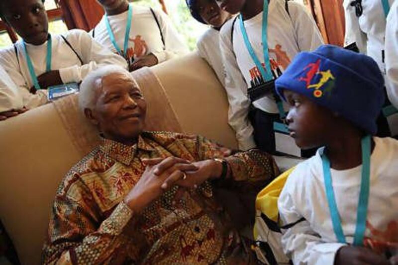 Nelson Mandela is surrounded by children at his home in Johannesburg yesterday.