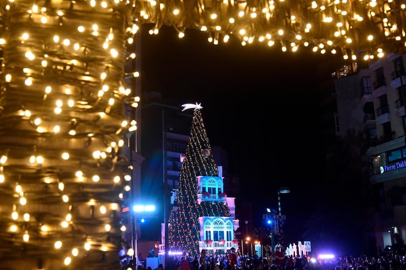 Lebanese people gather next to a giant Christmas tree which has been officially lit up at the Ashrafieh area in Beirut. EPA