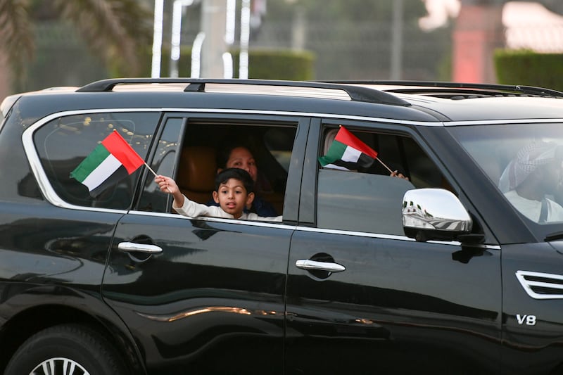 A child waves the UAE flag during the long weekend at Abu Dhabi Corniche. Khushnum Bhandari / The National