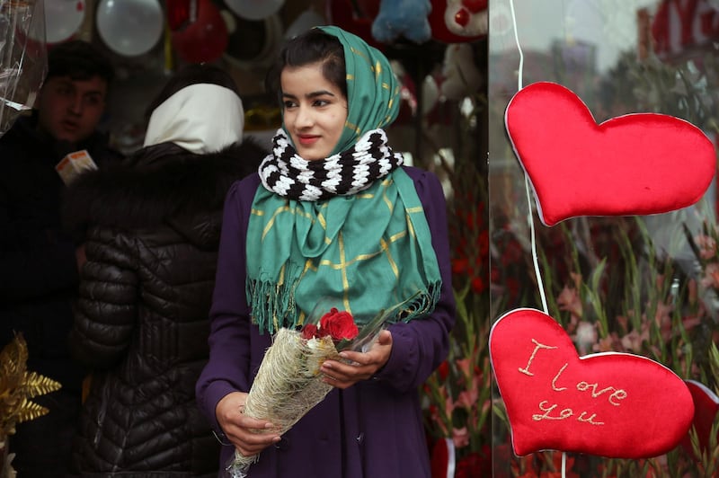 A woman holds a bouquet of roses as she leaves a flower shop in Kabul last year. AP