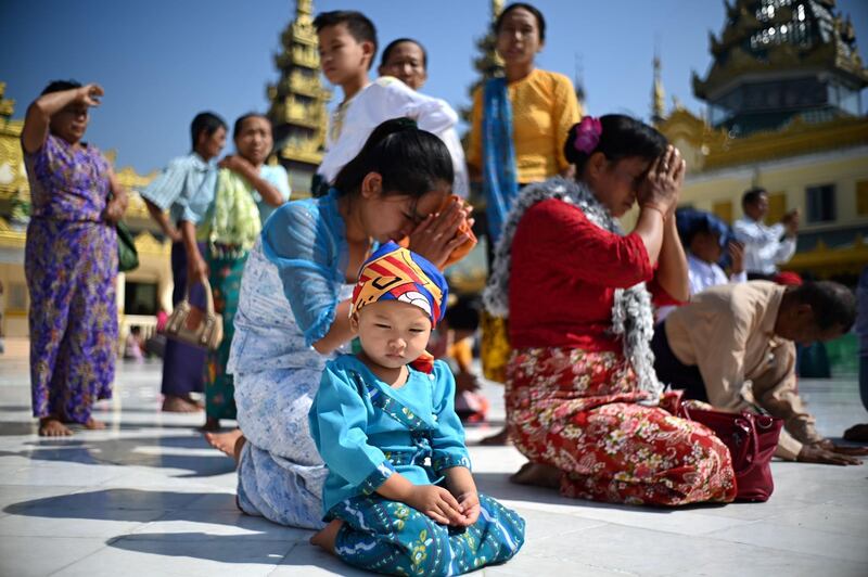 A child joins other devotees praying at the Shwedagon Pagoda in Yangon, Myanmar. AFP