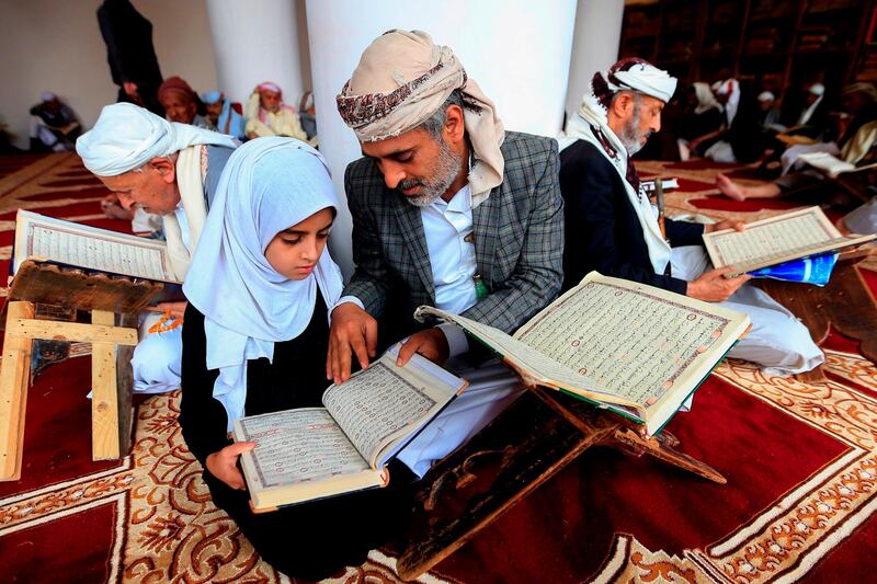A Yemeni man reads the Quran with his daughter at the Great Mosque of Sanaa. AFP