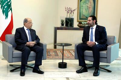 In this photo released by Lebanon's official government photographer Dalati Nohra, Lebanese President Michel Aoun, left, meets with Prime Minister Saad Hariri, ahead of a cabinet meeting, at the presidential palace, in Baabda, east of Beirut, Lebanon, Monday, Oct. 21, 2019. Protesters closed major roads around Lebanon ahead of an emergency Cabinet meeting on Monday, as politicians scrambled to put together a rescue plan for the country's crumbling economy and stem five days of mass anti-government protests.(Dalati Nohra via AP)