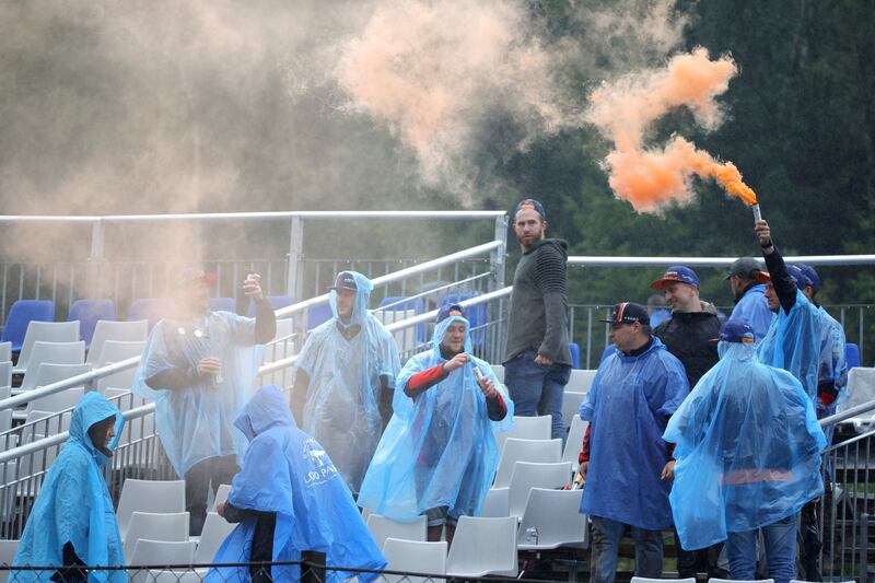 Spectators wait in the rain. AP