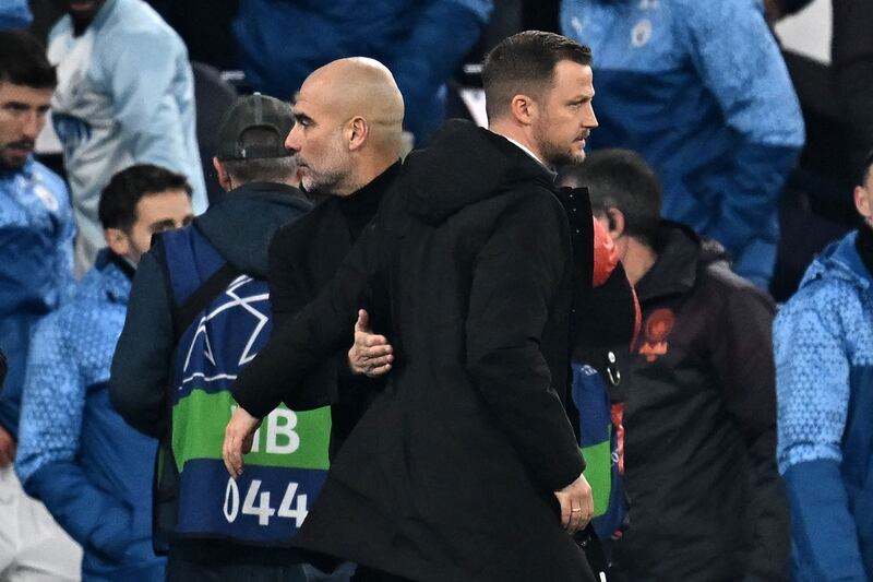 Manchester City manager Pep Guardiola and Copenhagen coach Jacob Neestrup embrace after the match. AFP