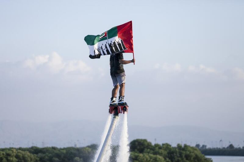 A man on a flyboard carries the flag at Ras Al Khaimah's Corniche. Reem Mohammed / The National