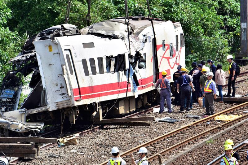 Workers survey the aftermath of a train derailment in Yilan county, northeastern Taiwan. AP Photo