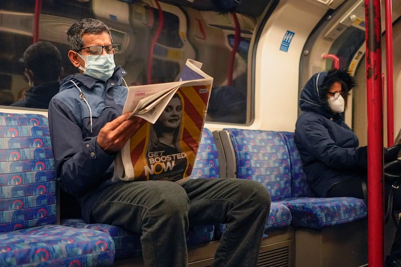 A traveller on a London Underground train. England's chief medical officer said the situation is likely to get worse as the Omicron variant drives a new wave of illness during the Christmas holidays. AP Photo
