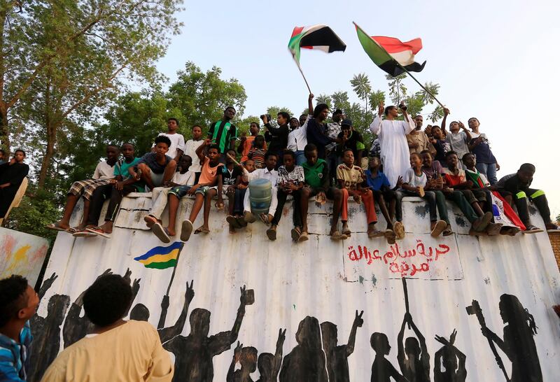 Sudanese people chant slogans and wave their national flags as they celebrate, after Sudan's ruling military council and a coalition of opposition and protest groups reached an agreement to share power during a transition period leading to elections, along the streets of Khartoum, Sudan, July 5, 2019. REUTERS/Mohamed Nureldin Abdallah