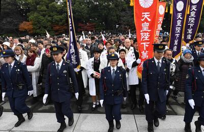 Police officers control the crowd during Japan's Emperor Akihito's birthday public appearance at the Imperial Palace in Tokyo on December 23, 2018. In a rare emotional address ahead of his abdication next year, Japanese Emperor Akihito said he took "deep comfort" that his long reign had been one of peace as he remembered the "countless lives" lost in World War II.  / AFP / Toshifumi KITAMURA
