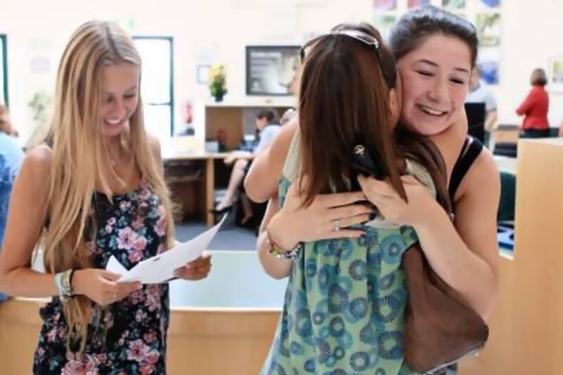 Emma Langley checks her year 13 A level results as her mother, Nicky Langley, embraces her classmate, Alice Taylor at Jumeirah College in Dubai yesterday. “It’s what I needed to go to university,” said 19-year-old Alice. Sarah Dea / The National