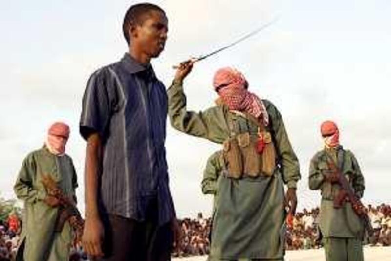 A Somali teenaged boy reacts to a lash after being convicted of raping a young a minor in Mogadishu, Somalia on March 9, 2009. Four young boys were convicted by Al-Shabab militant group which opposes the newly formed government of Sheikh Sharif Sheikh Ahmed. AFP PHOTO/Mohamed DAHIR