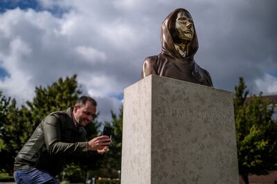 A passerby takes a photo of a Satoshi Nakamoto statue in Budapest, Hungary. The statue's creators, Reka Gergely and Tamas Gilly, used anonymised facial features as Nakamoto's true identify remains unconfirmed. Getty